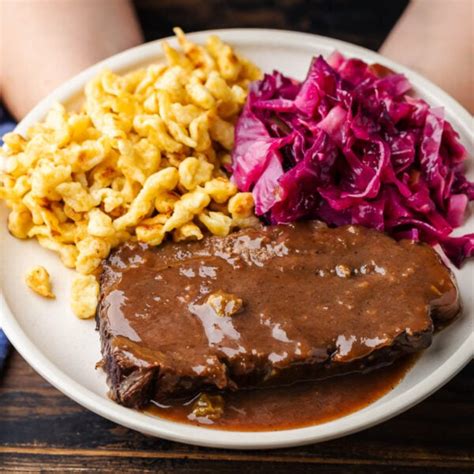  Rheinischer Sauerbraten!  Przygotuj się na aromatyczną ucztę z intensywnie rozsmaczającymi się mięsem i delikatną, słodko-kwaśną nutą so sosu.